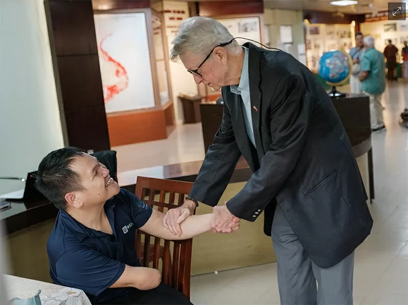 Cựu chiến binh chiến tranh Việt Nam Chuck Searcy với một người đàn ông bị thương do bom chùm Ảnh: Linh Phạm / DER SPIEGEL Cựu chiến binh chiến tranh Việt Nam Chuck Searcy với một người đàn ông bị thương do bom chùm Ảnh: Linh Phạm / DER SPIEGEL