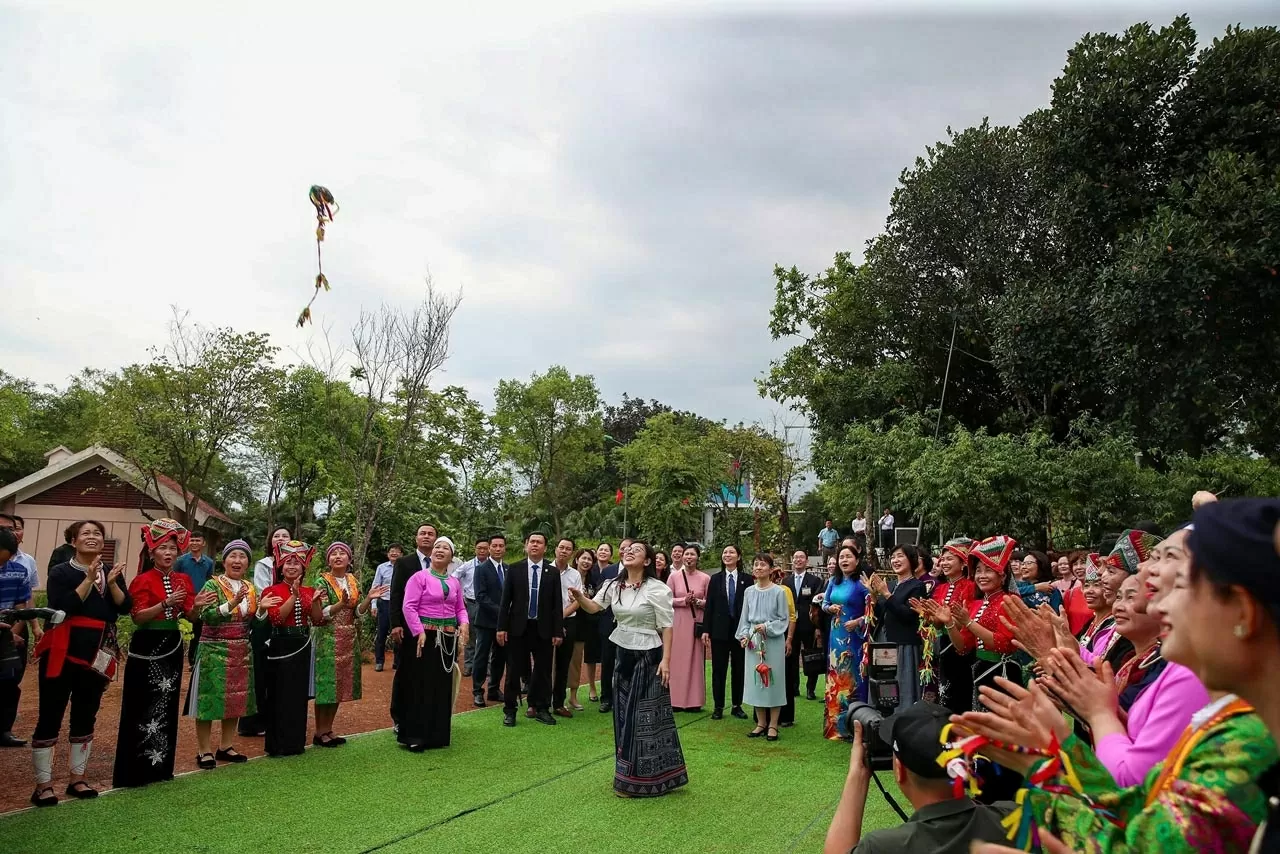 Dưới sự cổ vũ của những người xung quanh, hai Phu nhân đã cùng thử ném còn qua chiếc vòng tròn được treo trên một ngọn cây cao. Tiếng hò reo vang lên khi quả còn bay vút lên và lọt qua chiếc vòng.