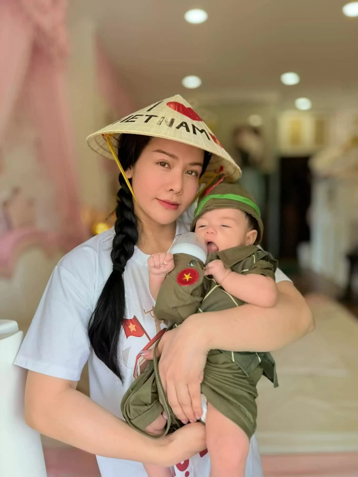 Bé Julia, con gái 3 tháng tuổi của Nhật Kim Anh, được khán giả khen dễ thương khi mặc trang phục người lính và ôm bình sữa.