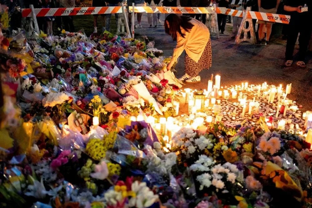 Một người phụ nữ đặt hoa tưởng niệm tại Vancouver, British Columbia, vào Chủ nhật, ngày 27 tháng 4. Tối hôm trước, một chiếc ô tô đã lao vào đám đông tại một lễ hội đường phố mừng văn hóa Philippines, khiến ít nhất 11 người thiệt mạng và hàng chục người bị thương. (Nguồn: Reuters)