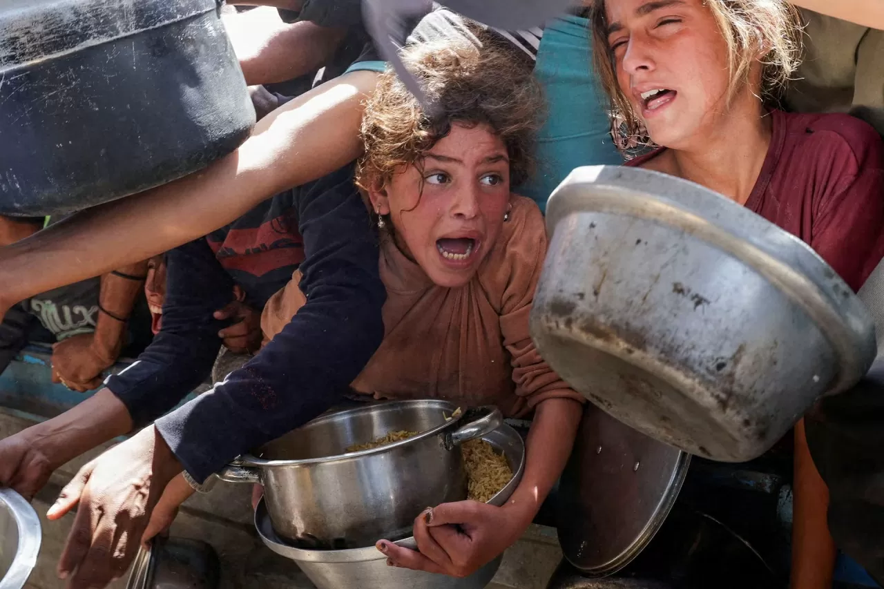 Một người Palestine phản ứng khi mọi người tập trung nhận thức ăn do một bếp ăn từ thiện nấu, tại Khan Younis, phía nam Dải Gaza, ngày 29 tháng 4. (Nguồn: Reuters)