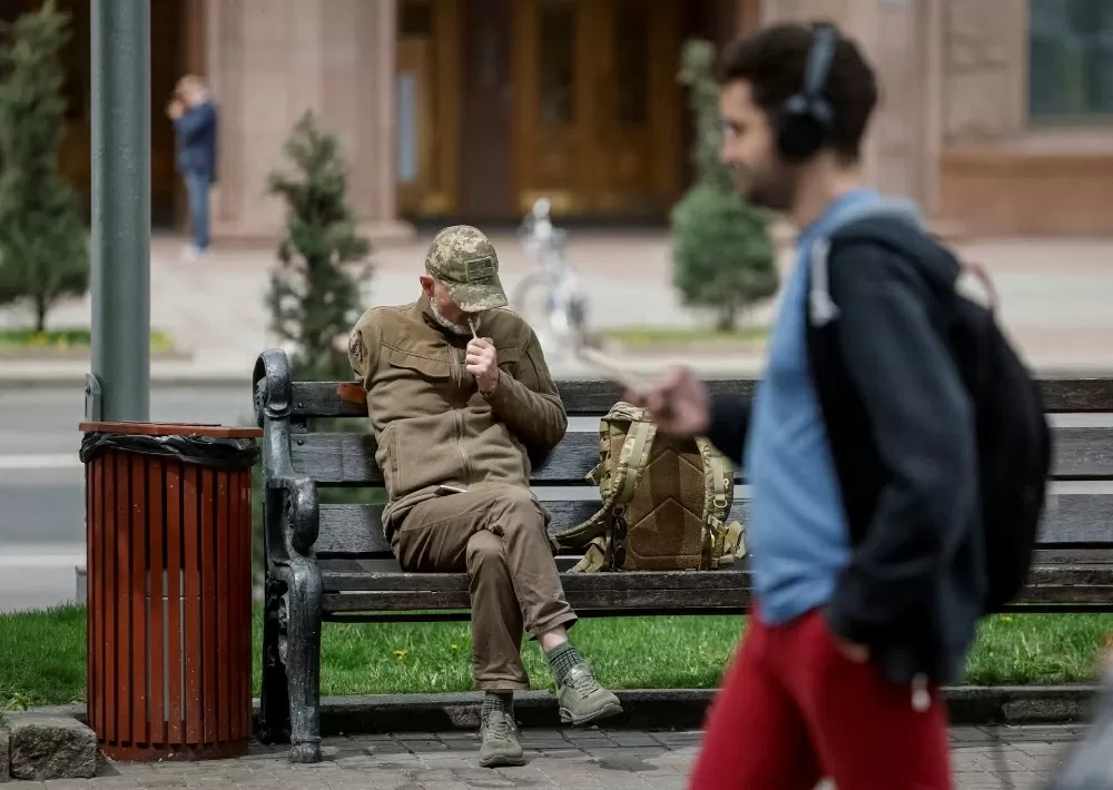 Ông Yurii, 57 tuổi, là một quân nhân đã phải cắt cụt chi do sự tàn khốc của cuộc xung đột giữa Nga và Ukraine. Trong ảnh, ông đang ngồi nghỉ và hút thuốc trên một chiếc ghế trong trung tâm Kiev, Ukraine, ngày 29/4. (Nguồn: Reuters)