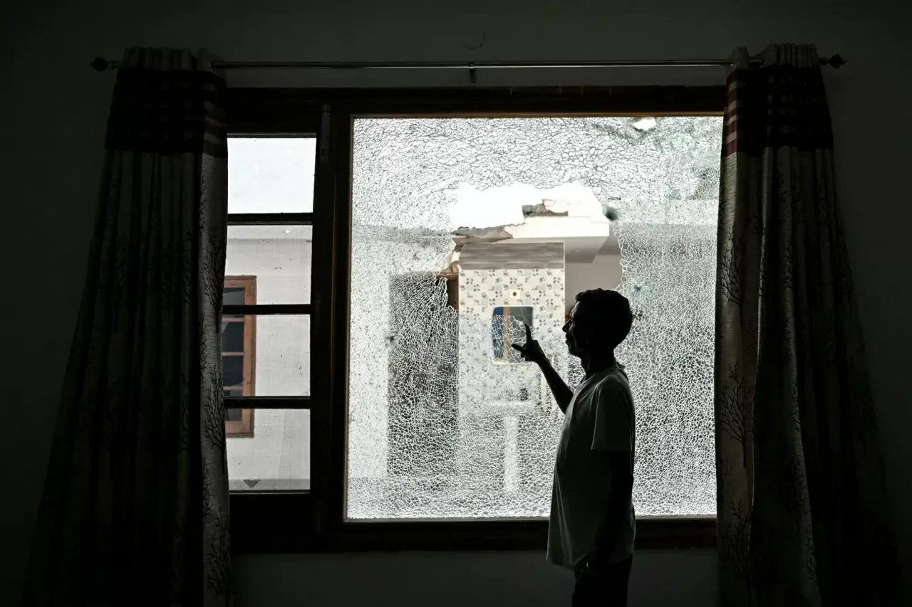 Một người đàn ông chỉ vào khung cửa sổ bị vỡ của một ngôi nhà sau vụ pháo kích qua biên giới tại thị trấn Arnia, gần khu vực biên giới ở Jammu, trong bối cảnh căng thẳng biên giới giữa Ấn Độ và Pakistan leo thang. Hai quốc gia đã đồng ý một lệnh ngừng bắn do Mỹ làm trung gian vào cuối tuần trước, tuy nhiên, tính bền vững của thỏa thuận này đã bị đặt dấu hỏi sau khi có báo cáo về các vụ nã pháo và nổ xảy ra chỉ vài giờ sau khi thỏa thuận được công bố tại khu vực Kashmir do Ấn Độ kiểm soát. (Nguồn: AFP)