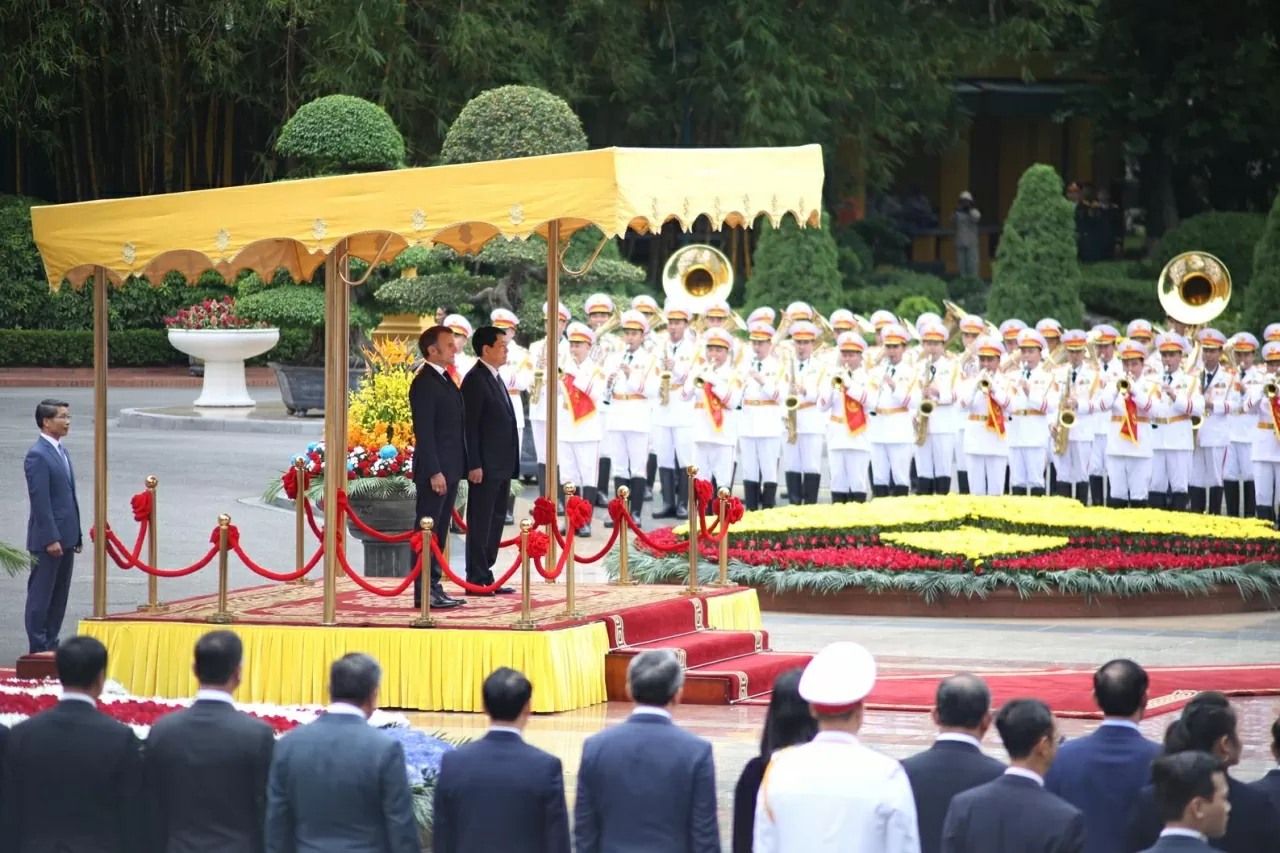 Chủ tịch nước Lương Cường nhiệt liệt chào mừng Tổng thống Pháp Emmanuel Macron thăm chính thức Việt Nam. Hai nhà lãnh đạo bước lên bục danh dự, trong khi quân nhạc cử Quốc thiều hai nước. (Ảnh: Thành Long)