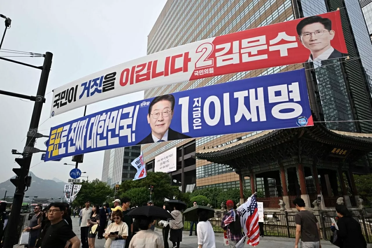 Băng rôn cổ động ứng viên Kim Moon Soo (trên) và Lee Jae Myung (dưới) trên một góc phố Seoul ngày 31-5 - Ảnh: AFP