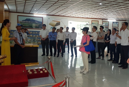 Hướng dẫn viên giới thiệu giá trị các di vật phát hiện trong không gian văn hóa Tây Đô tới du khách. (Nguồn: TTXVN)