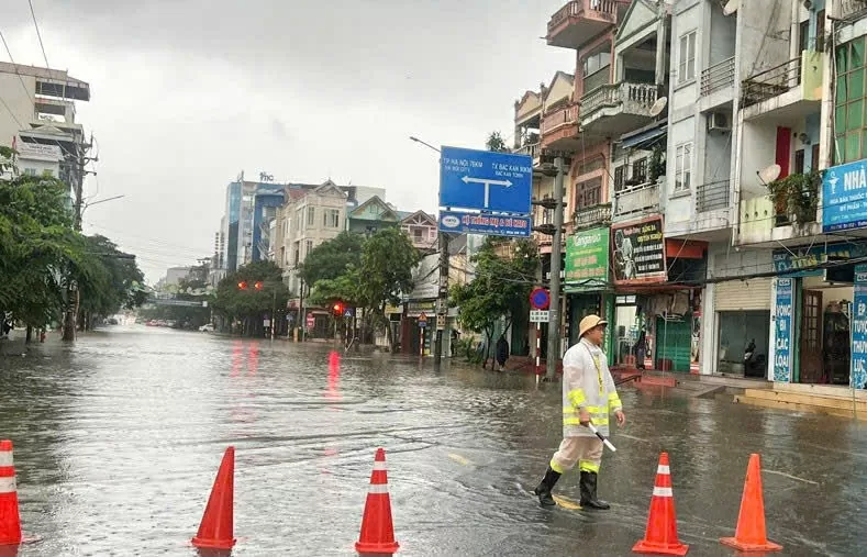 Lực lượng CSGT Công an tỉnh Thái Nguyên dầm mưa phân luồng giao thông. (Nguồn: Vietnamnet)