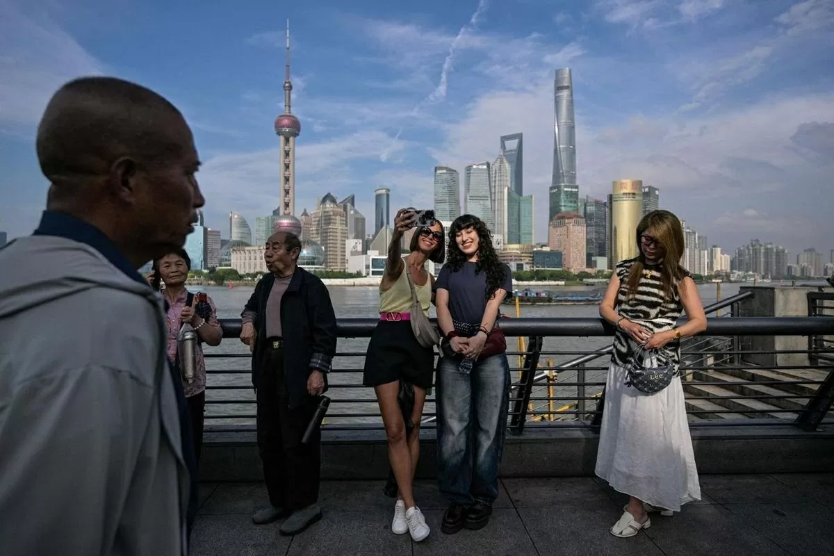 Du khách chụp ảnh selfie trên phố đi bộ Bund ven sông Hoàng Phố, Thượng Hải, ngày 20/5. Ảnh: AFP-Yonhap