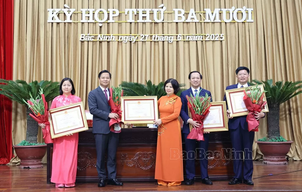 Thừa ủy quyền, Chủ tịch HĐND tỉnh Nguyễn Hương Giang trao Huân chương Lao động hạng Nhì, hạng Ba cho các cá nhân.