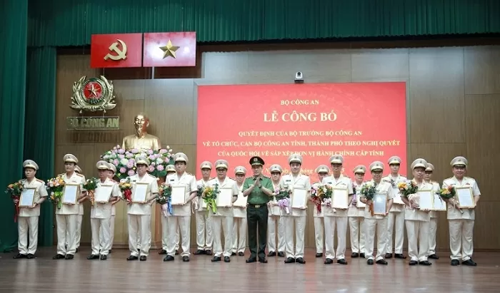 Bộ trưởng Lương Tam Quang trao Quyết định và tặng hoa chúc mừng các đồng chí Giám đốc Công an 23 địa phương sau sáp nhập.