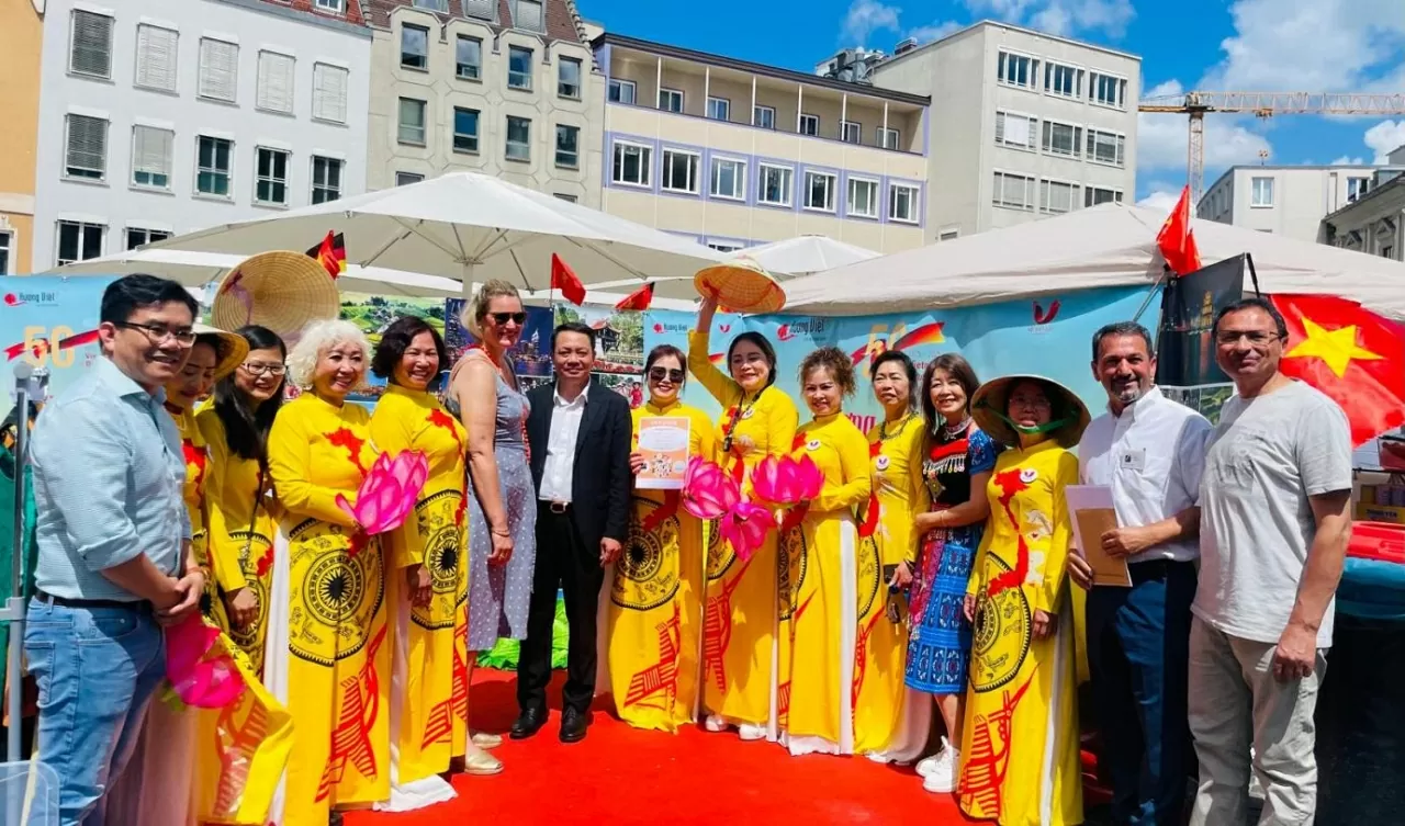 Bà Eva Weber – Thị trưởng thành phố Augsburg và ông Phạm Huy Phương – Trưởng ban Công tác Cộng đồng Đại sứ quán Việt Nam tại Đức (chính giữa) chụp ảnh lưu niệm cùng cộng đồng người Việt tại TP. Augsburg.