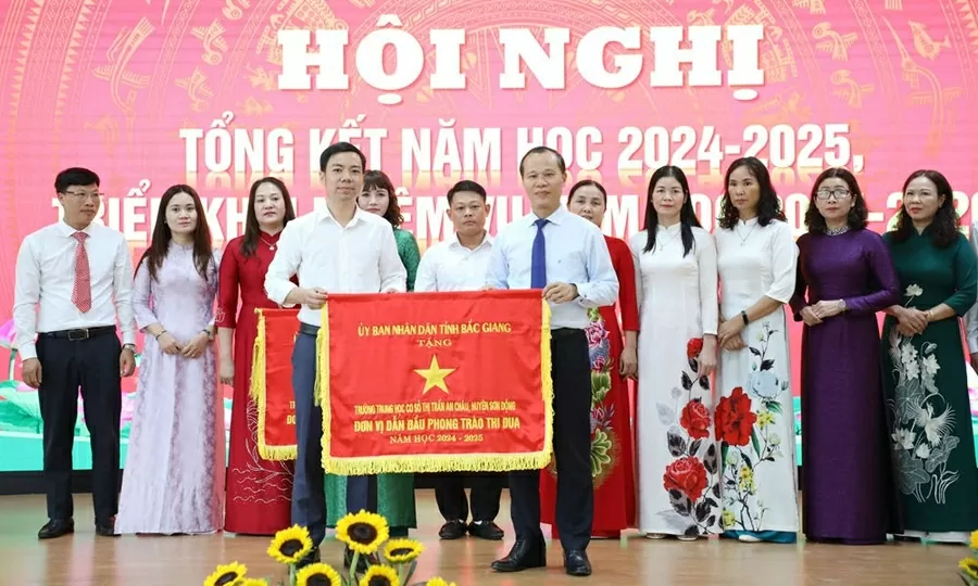 Ông Mai Sơn trao Cờ đơn vị dẫn đầu phong trào thi đua năm học 2024-2025 cho Trường THCS thị trấn An Châu. (Nguồn: Báo Bắc Giang)