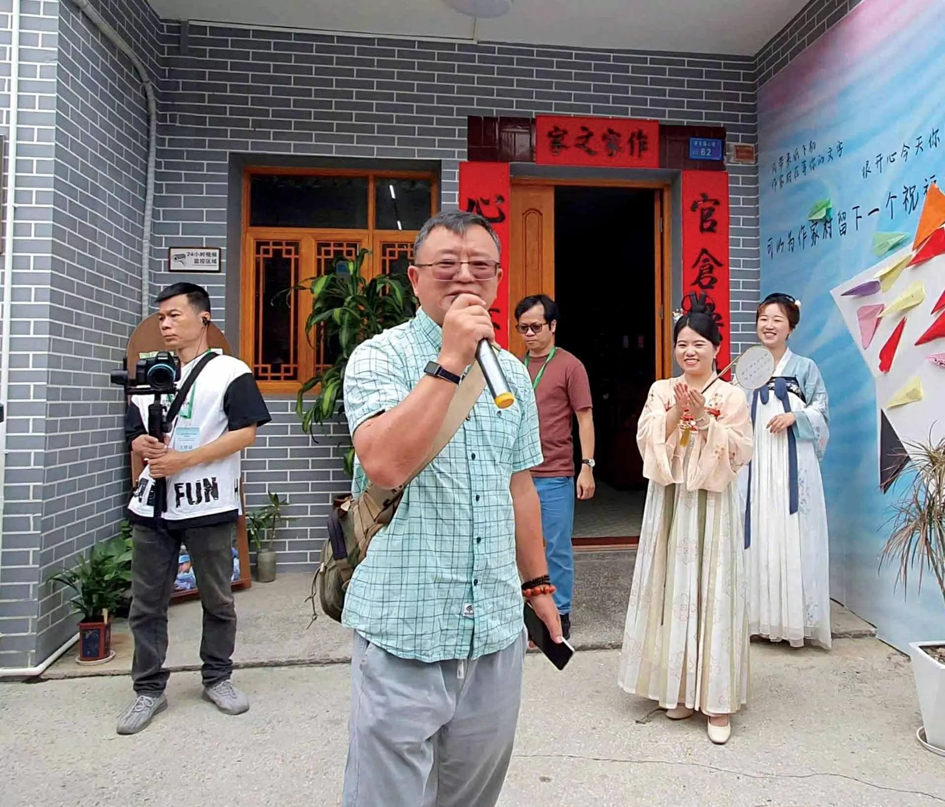 Nhà thơ Vương Nhất Đinh ngẫu hứng đọc thơ tại ngã ba làng Nhà văn Đông Quản. (Ảnh TGCC)