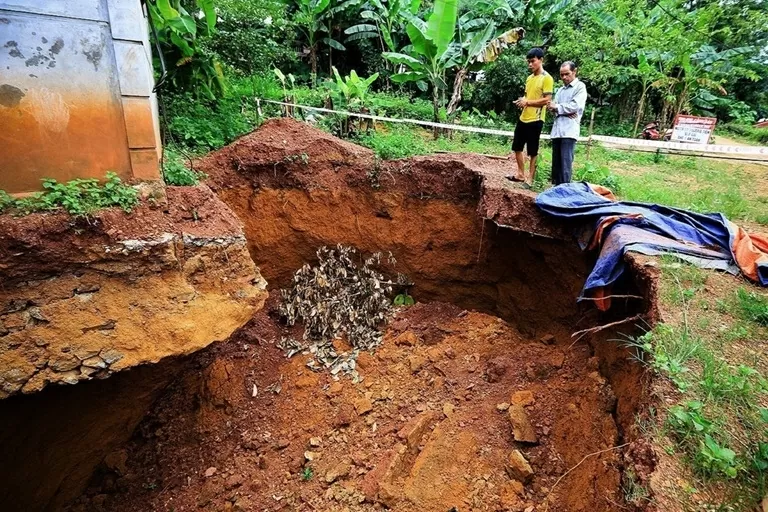Hố sụt lún làm lộ toàn bộ phần móng và khoét sâu vào bên trong móng nhà kiên cố khoảng 1,5m. (Nguồn: TTXVN)