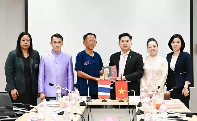 Tổng lãnh sự Đinh Hoàng Linh trao tặng cuốn sách “Bác Hồ ở Thái Lan” cho Phó Giáo sư, Tiến sĩ Thammarak Laongnual, Hiệu trưởng Đại học Hoàng gia Ubon Ratchathani. (Ảnh: Khánh Ly/Vietnam+)