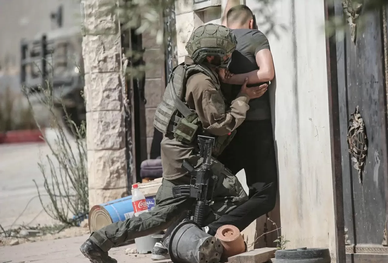 Một binh sĩ Israel khám xét một thanh niên Palestine khi anh cố gắng vượt qua vào trại tị nạn Tulkarm ở Bờ Tây, trong bối cảnh các chiến dịch quân sự của Israel tiếp tục diễn ra tại khu vực nhằm chuẩn bị cho kế hoạch phá dỡ một ngôi nhà. Các vụ bạo lực do