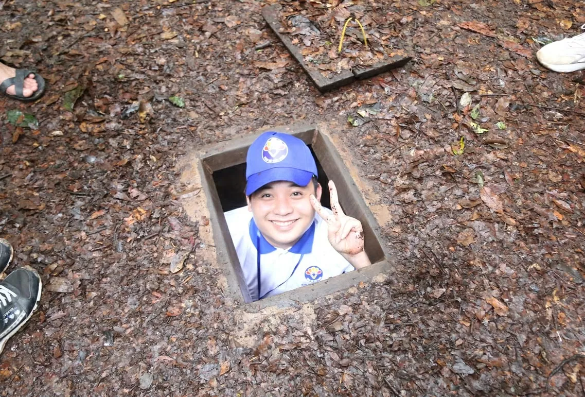 Kiều bào trẻ thích thú lần đầu tiên trải nghiệm chui địa đạo. (Ảnh: Thành Long) Kiều bào trẻ thích thú lần đầu tiên trải nghiệm chui địa đạo. (Ảnh: Thành Long)