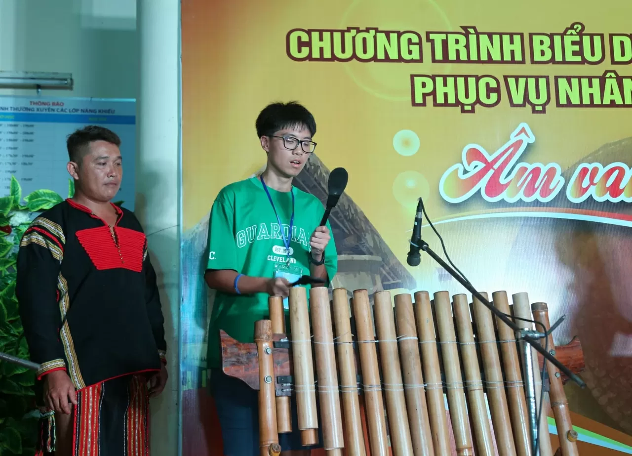 Bạn Đỗ Đắc Bằng, kiều bào đến từ Liên Bang Nga hào hứng khi được chơi thử đàn Đinh Pá, nhạc cụ dân tộc truyền thống của người Êđê. (Ảnh: Thành Long)