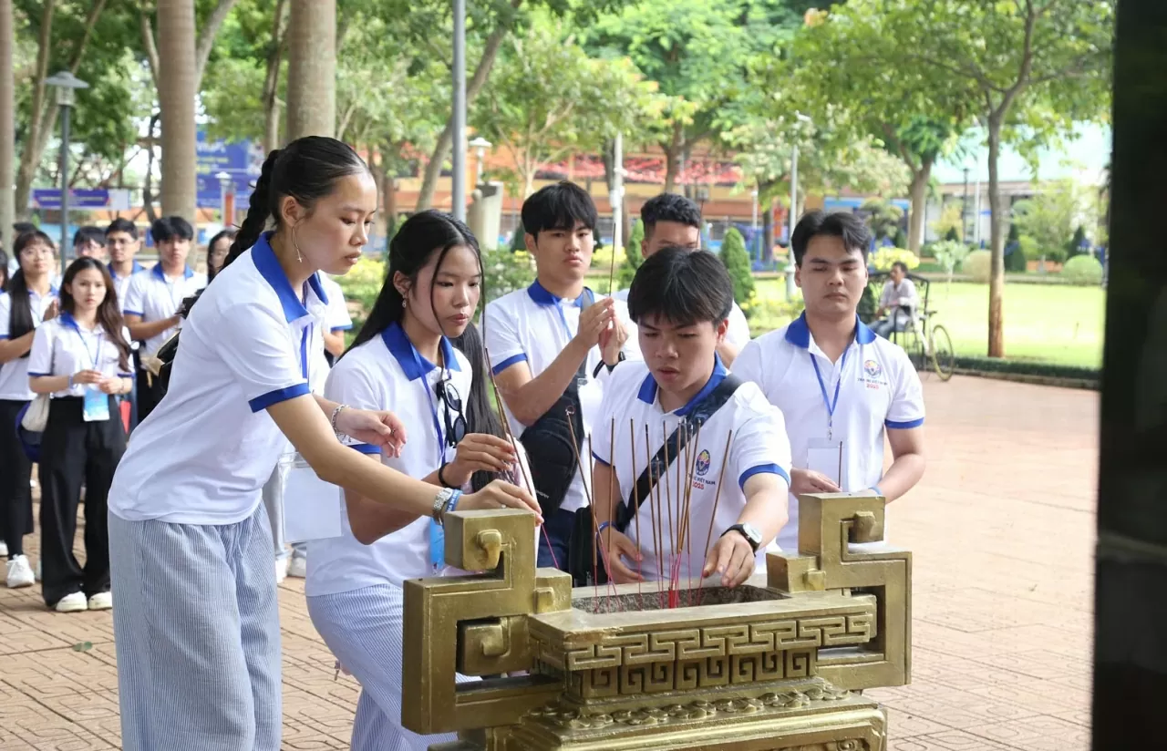 Kiều bào trẻ thành kính thắp hương tưởng niệm 100 chiến sĩ Nam tiến đã hy sinh anh dũng. (Ảnh: Thành Long)
