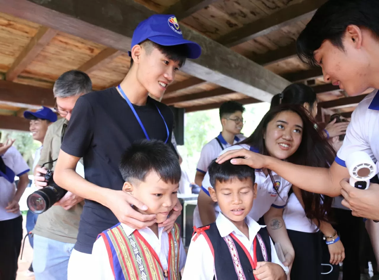 Các kiều bào trẻ thăm hỏi và giao lưu với các em học sinh Kon Tum. (Ảnh: Thành Long)