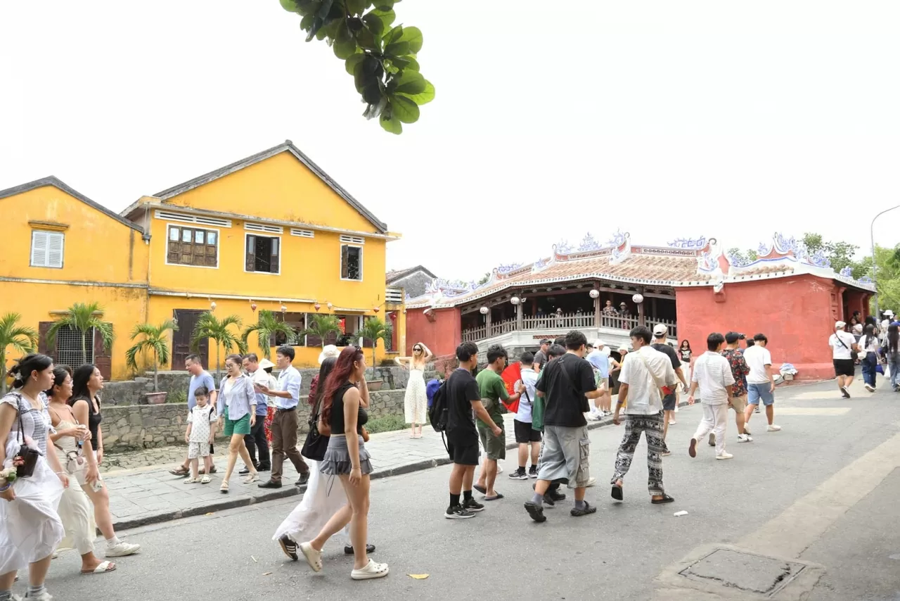 Đoàn thanh niên, sinh viên kiều bào thăm cây Cầu Chùa – biểu tượng của Hội An. (Ảnh: Thành Long)