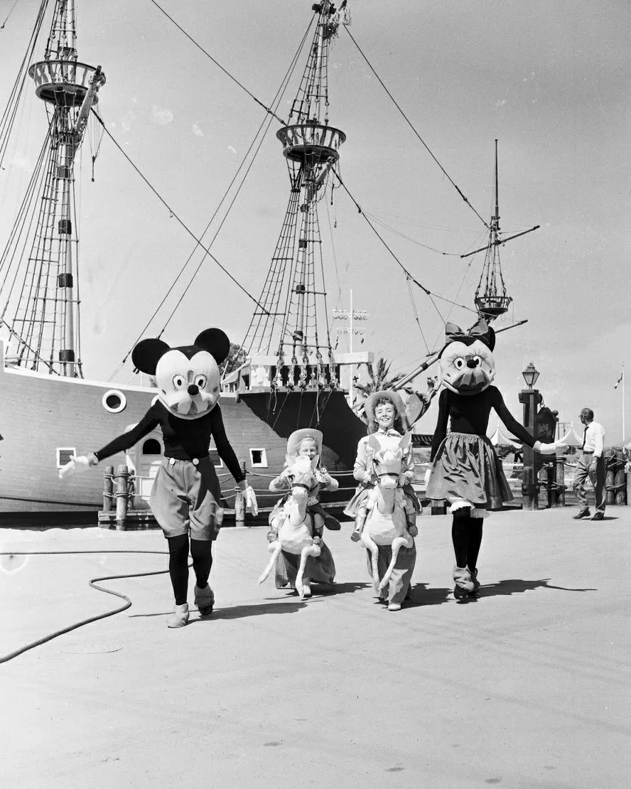 Chuột Mickey và Minnie xuất hiện cùng các em nhỏ bên cạnh mô hình tàu cướp biển trong ngày khai trương Disneyland. (Nguồn: Getty) 