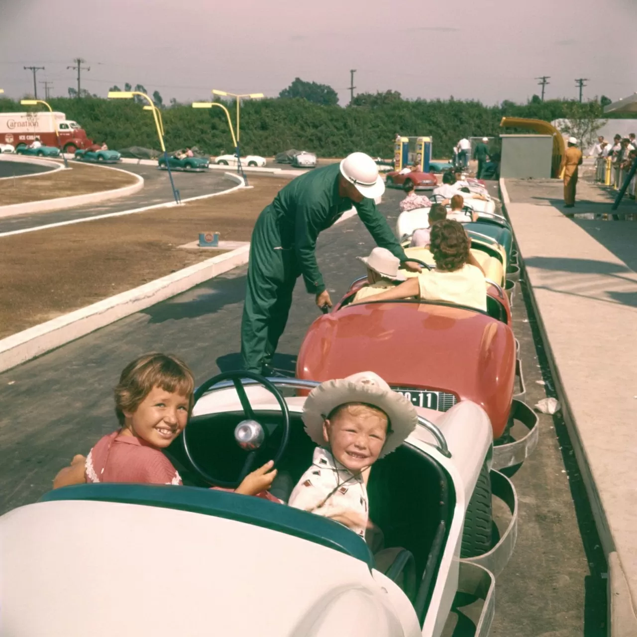 Các em nhỏ tạo dáng chụp ảnh lưu niệm trước khi trải nghiệm trò chơi đua xe tại điểm tham quan Autopia. (Nguồn: Shutterstock)