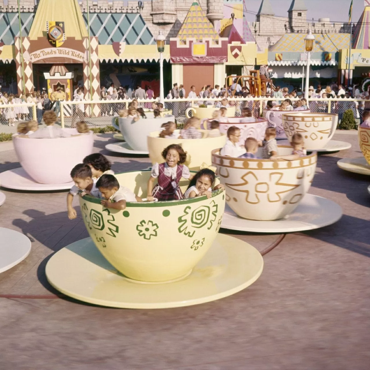 Trẻ em thích thú khi ngồi trong những chiếc tách trà xoay của trò chơi Mad Tea Party, lấy cảm hứng từ buổi tiệc trà trong phim “Alice xứ sở thần tiên”. (Nguồn: Shutterstock)