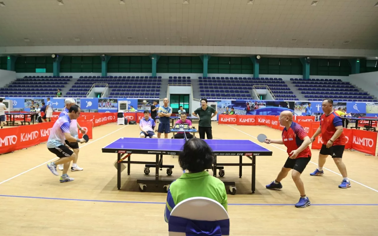 Đồng chí Đỗ Văn Chiến, Ủy viên Bộ Chính trị, Chủ tịch Ủy ban Trung ương Mặt trận Tổ quốc Việt Nam bắt cặp cùng ông Vũ Chí Hòa, trưởng Ban công tác xã hội thi đấu trận giao lưu mở màn bóng bàn với 2 vdv của Liên đoàn Bóng bàn Việt Nam. (Ảnh: Thành Long)