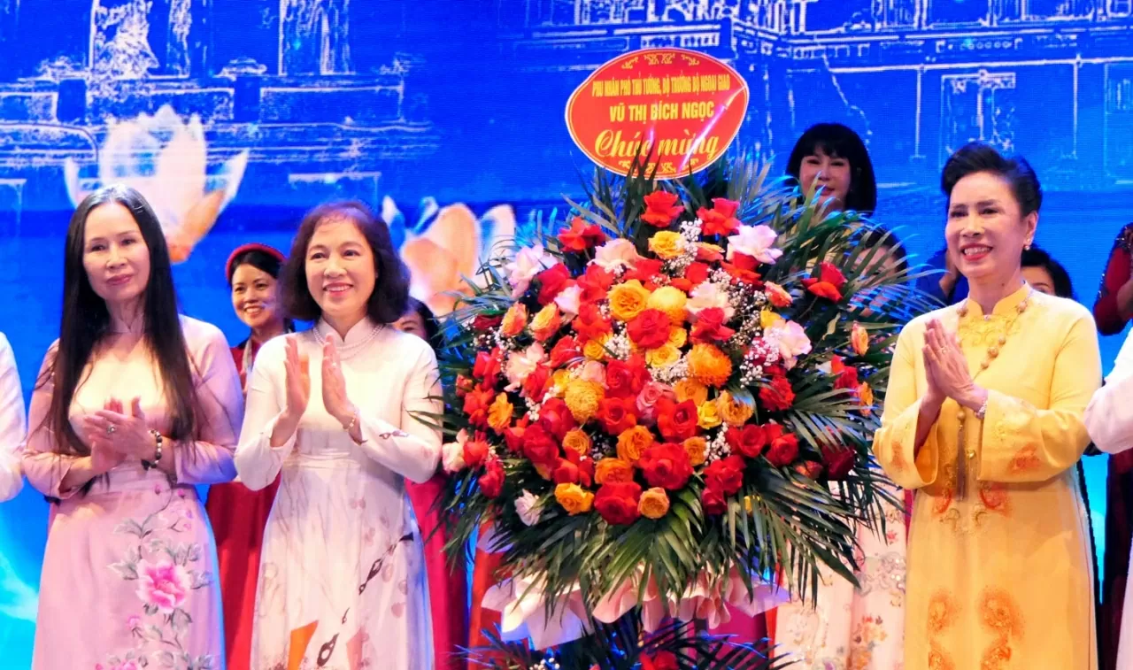 Phu nhân Vũ Thị Bích Ngọc tặng lẵng hoa chúc mừng Ban Chấp hành Hiệp hội Văn hóa Áo dài Việt Nam. (Ảnh: Thành Long)