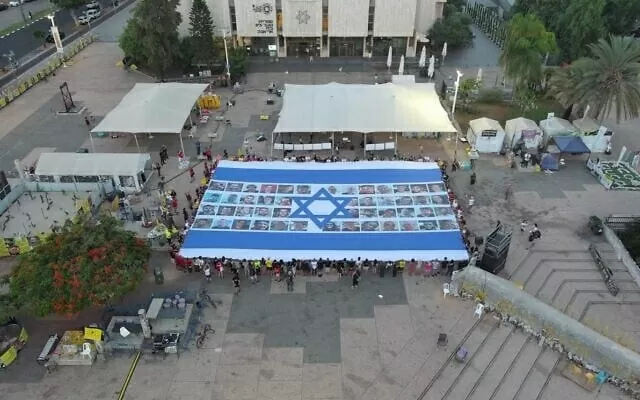 Một lá cờ khổng lồ của Israel có in hình khuôn mặt của các con tin được trưng bày tại Quảng trường Con tin ở Tel Aviv, ngày 17/8. (Nguồn: Times of Israel)