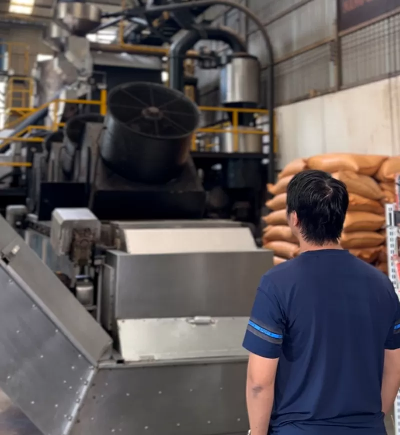 Hoàng Đại Phong đứng trong nhà máy.