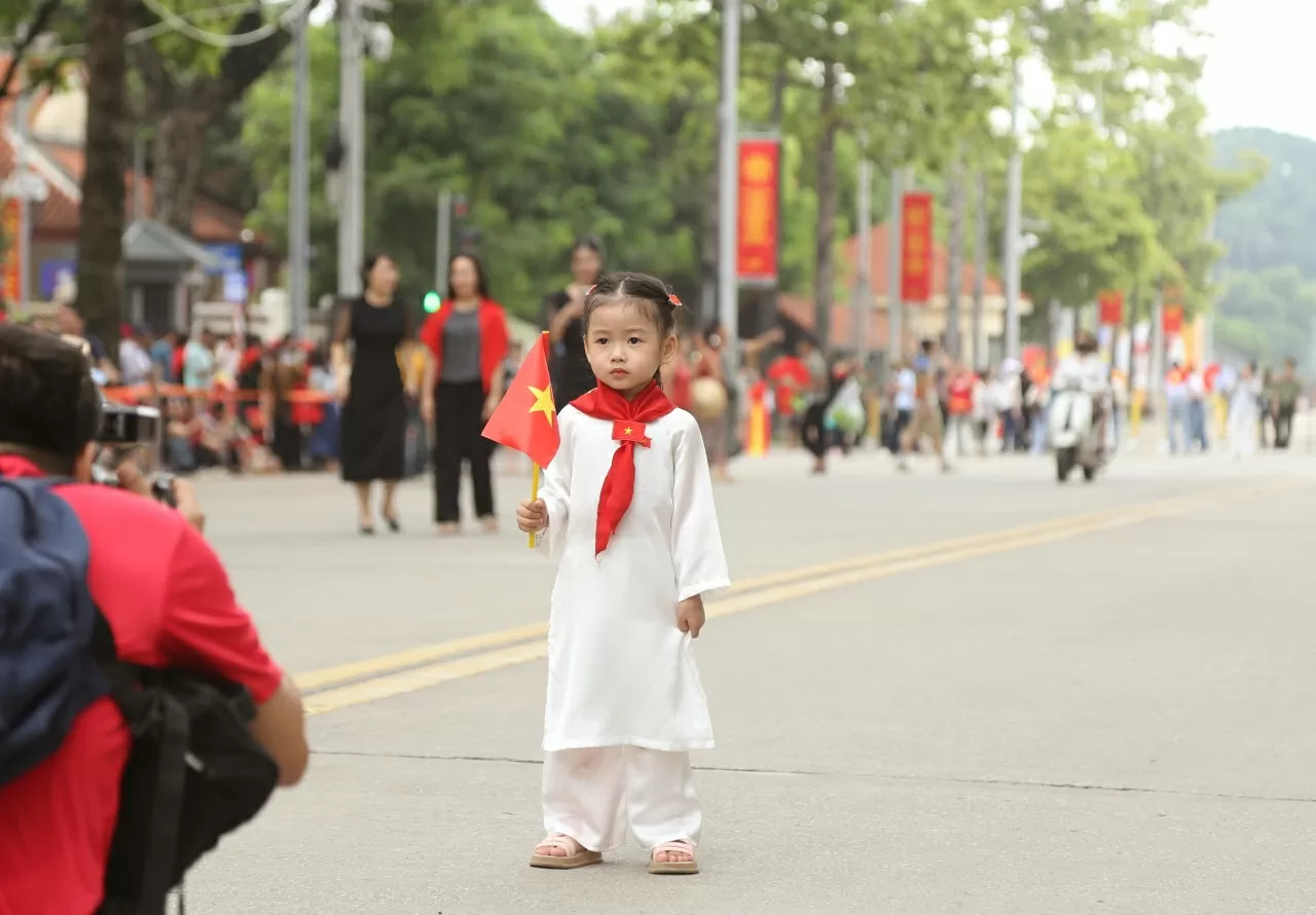 Cờ đỏ sao vang, khăn và áo dài rạng rỡ khắp các tuyến phố Thủ đô. (Ảnh: Thành Long)