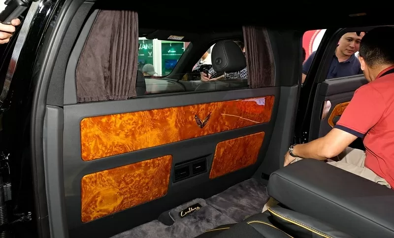 Ở phía sau, khoang hành khách mang đậm phong cách thương gia với vách ngăn gỗ Golden Nanmu, logo mạ vàng và hệ thống rèm điện tích hợp kính cách âm.