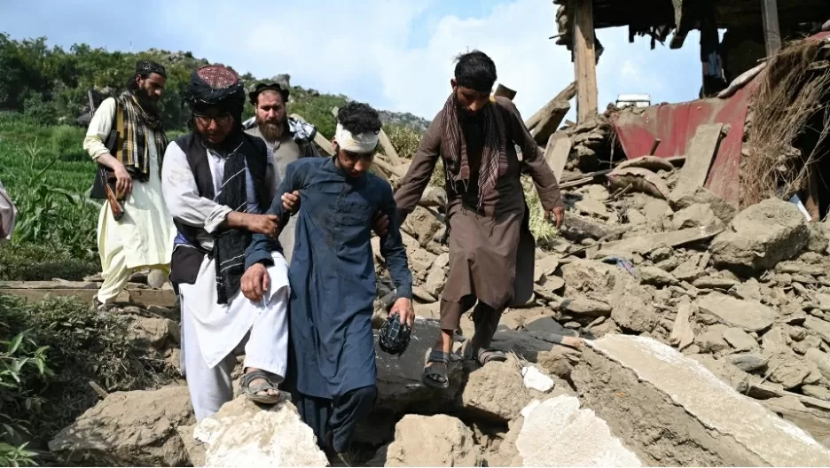 Những người đàn ông Afghanistan giúp đỡ một người đàn ông bị thương khi họ đi ngang qua một ngôi nhà bị hư hại sau trận động đất và dư chấn ở làng Mazar Dara thuộc Nurgal, một huyện của tỉnh Kunar, miền Đông Afghanistan, vào ngày 1 tháng 9. (Nguồn: Getty Images)