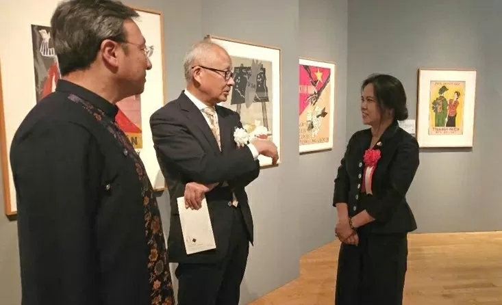 Tổng Lãnh sự Vũ Chi Mai hướng dẫn khách thăm quan và nói về ý nghĩa lịch sử của từng tranh vẽ cổ động kháng chiến.