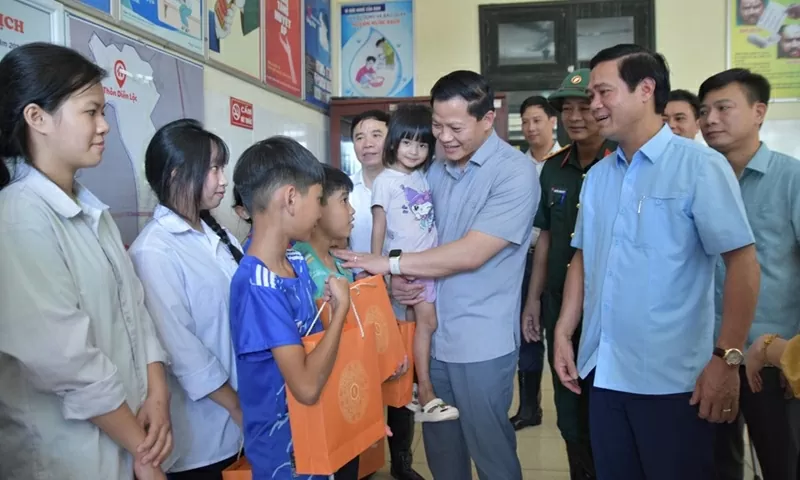 Chủ tịch UBND tỉnh Vương Quốc Tuấn động viên các em nhỏ tại xã Tam Giang.