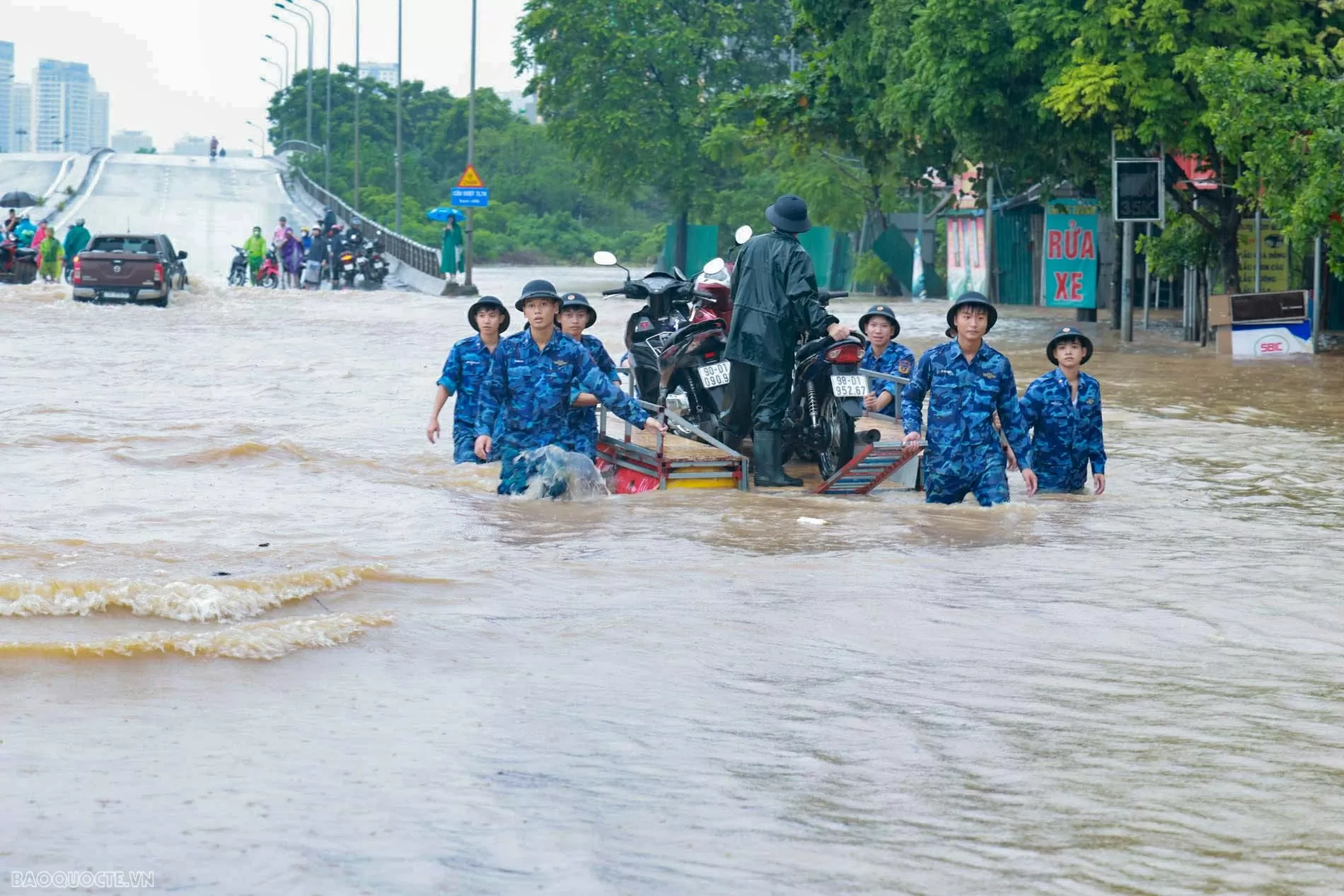 Lực lượng cảnh sát biển hỗ trợ người dân di chuyển qua vùng ngập sâu khu vực cầu Ngà