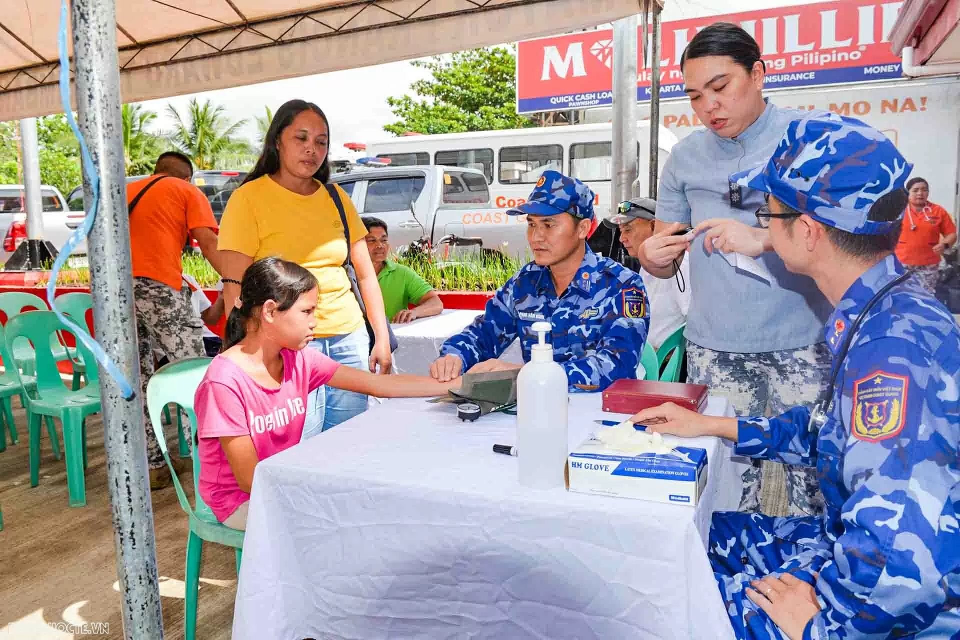 Cán bộ quân y Cảnh sát biển Việt Nam thực hiện khám bệnh cho người dân vùng bị động đất Philippines. (Ảnh: Chu Anh)