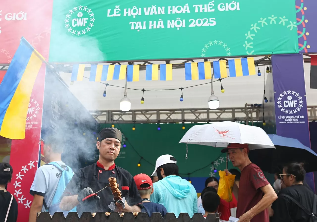 Người đầu bếp nướng thịt trước gian hàng nước Ukraina, tạo nên sức hút khó cưỡng đối với những thực khách thăm quan. (Ảnh: Thành Long)