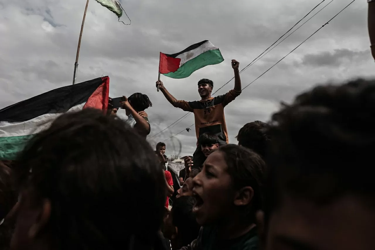 Người Palestine ăn mừng tin tức về thỏa thuận ngừng bắn tại một trại tị nạn ở Deir-al-Balah, Dải Gaza, vào thứ Năm, ngày 9 tháng 10. Trước đó một ngày, Tổng thống Mỹ Donald Trump thông báo rằng Hamas và Israel đã đạt được thỏa thuận về bước đầu tiên của kế hoạch ngừng bắn — một bước đột phá lớn, được nhiều người đón nhận với sự lạc quan thận trọng. Giai đoạn đầu của kế hoạch sẽ bao gồm: Trả tự do cho toàn bộ con tin người Israel, Rút quân đội Israel khỏi Gaza về một ranh giới đã được thỏa thuận, Và phóng thích một số tù nhân và người bị giam giữ Palestine. Ông Trump cũng thông báo rằng một “hội đồng hòa bình” đang được thành lập nhằm duy trì hòa bình lâu dài trong khu vực. Không khí hân hoan tràn ngập các đường phố ở cả Israel và Gaza vào sáng sớm thứ Năm, xen lẫn niềm nhẹ nhõm và hy vọng thận trọng rằng hai năm đổ máu có thể sắp đi đến hồi kết. Tuy nhiên, một số vấn đề còn tồn tại có thể cản trở tiến trình, bao gồm việc giải giáp Hamas và cơ chế quản trị tại Gaza. (Nguồn: Anadolu)