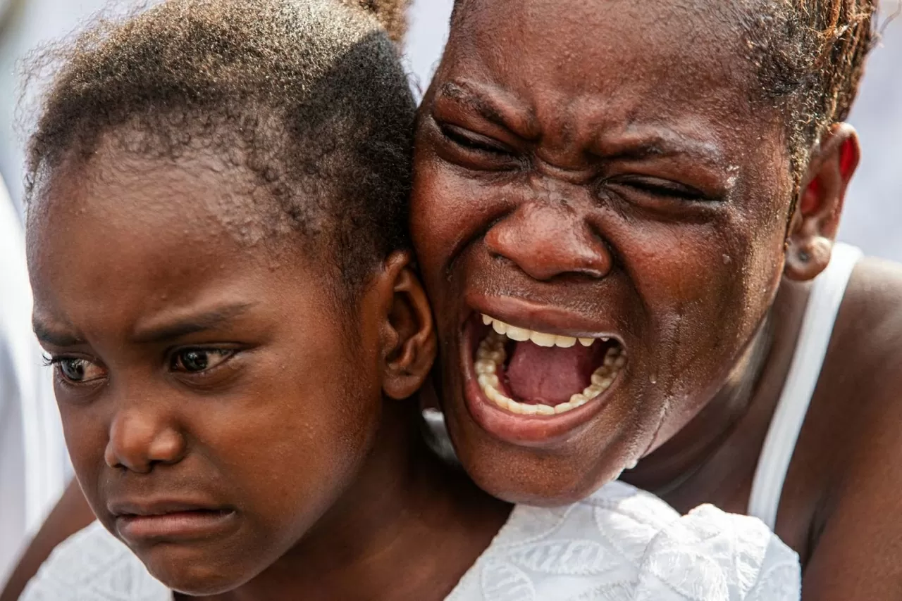 Một người phụ nữ bật khóc trong tang lễ được tổ chức vào thứ Bảy, ngày 4 tháng 10, dành cho tám nạn nhân thiệt mạng trong một vụ không kích bằng máy bay không người lái hồi tháng trước tại thủ đô Port-au-Prince, Haiti. Theo lời thân nhân và các nhà hoạt động chia sẻ với Hãng tin Associated Press hồi tháng trước, vụ tấn công — nhằm mục tiêu là một thủ lĩnh băng nhóm tình nghi — đã khiến hơn một chục người thiệt mạng, trong đó ít nhất có tám trẻ em. (Nguồn: CNN)