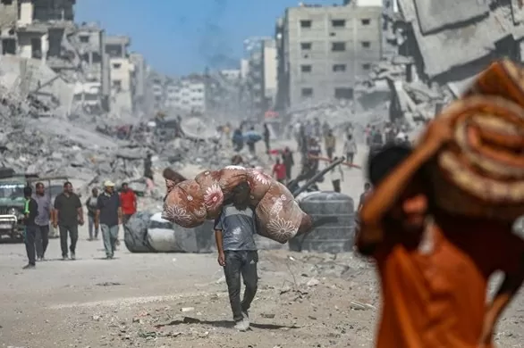 Người dân Palestine di tản giữa đống đổ nát của những tòa nhà bị phá hủy trong bối cảnh lệnh ngừng bắn giữa Israel và Hamas, tại thành phố Gaza (Nguồn: EPA)