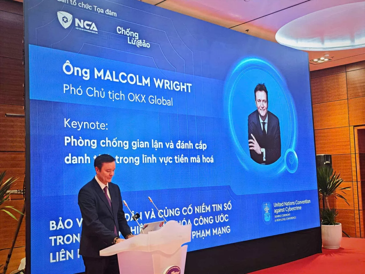 Ông Malcolm Wright, Phó Chủ tịch phụ trách pháp chế của OKX Global, trình bày tham luận tại Tọa đàm, ngày 26/10. 