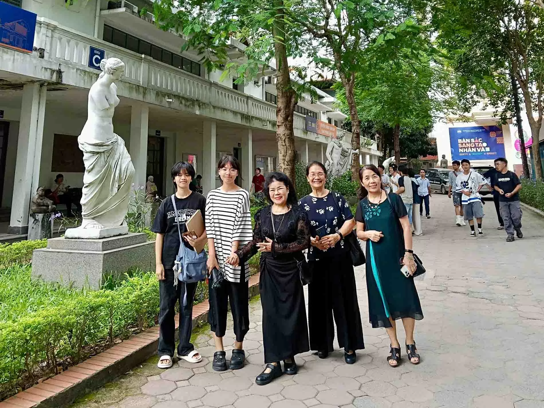 Họa sĩ Văn Dương Thành (giữa) về thăm trường. (Ảnh TGCC)