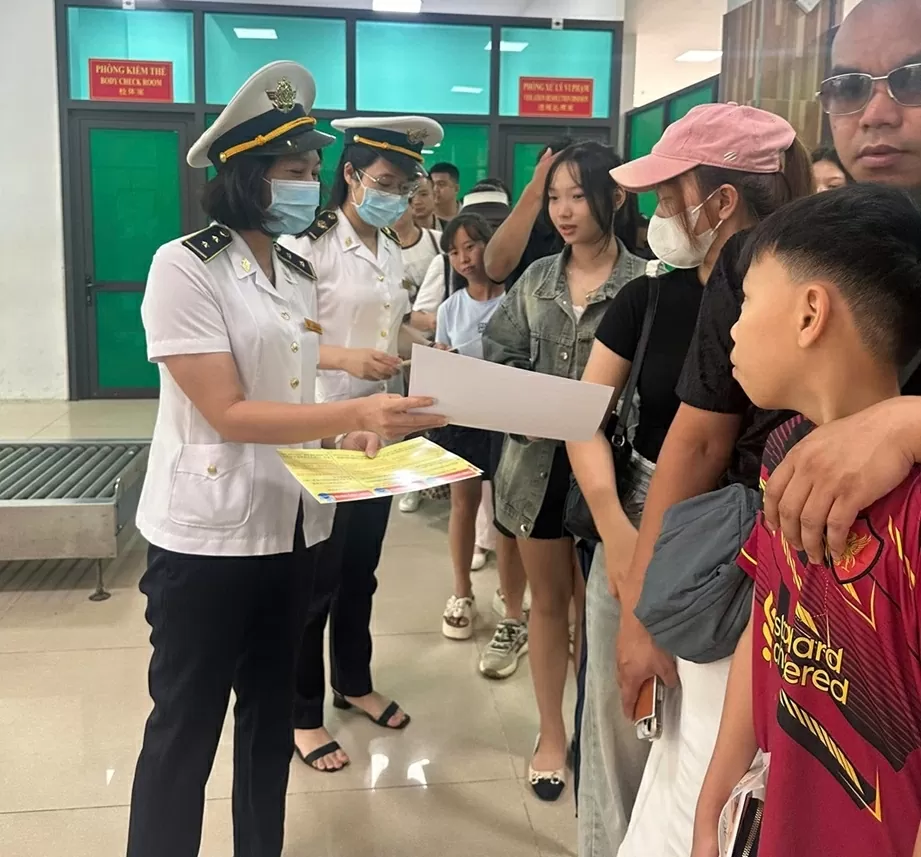 Kiểm dịch viên Trung tâm KDYT tuyên truyền phòng chống dịch bệnh lây truyền qua biên giới cho người dân tham gia XNC tại CK quốc tế LC