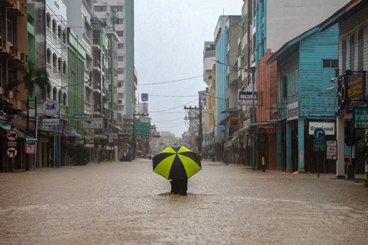 Một người lội qua khu vực ngập lụt tại quận Hat Yai, tỉnh Songkhla, Thái Lan. (Nguồn: The Guardian)