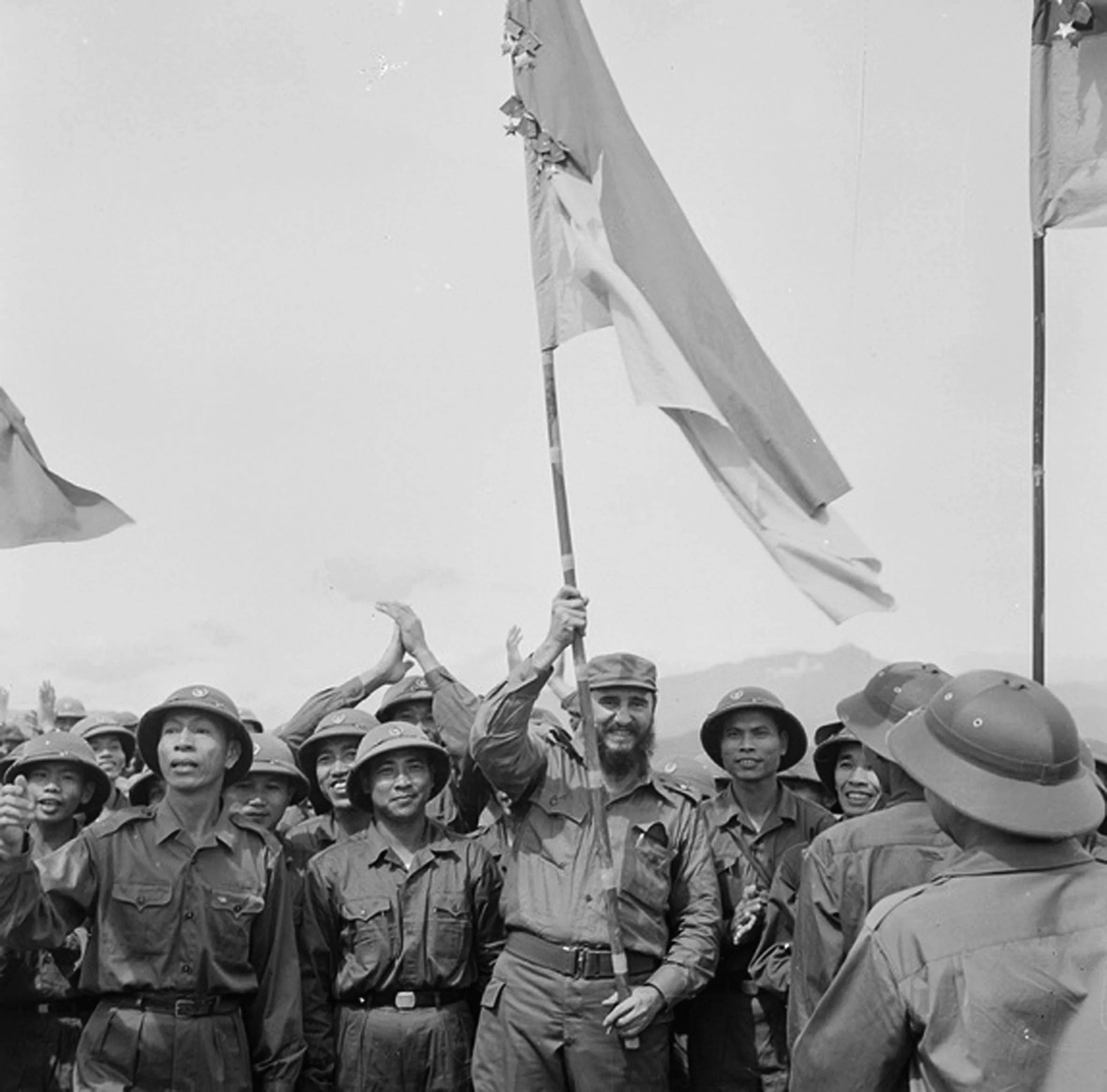 Chủ tịch Fidel Castro phất cao lá cờ bách chiến, bách thắng lấp lánh huân chương của Đoàn Khe Sanh, Quân Giải phóng Trị Thiên - Huế tại Cao điểm 241 trong chuyến thăm vùng Giải phóng miền Nam Việt Nam, ngày 16/9/1973. (Nguồn: TTXVN)