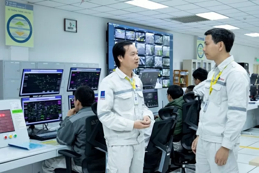 Kỹ sư Trần Đại Nghĩa - Quản đốc phân xưởng ure của nhà máy đạm Cà Mau (áo trắng bên phải) đang trao đổi với kỹ sư vận hành trong phòng điều khiển trung tâm nhà máy. Ảnh: A.N