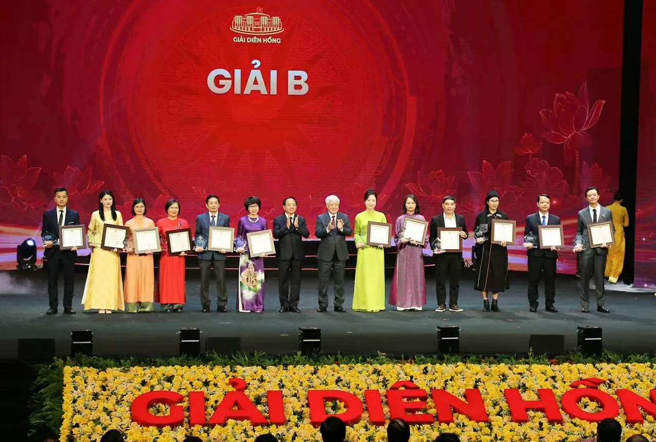 Phó Chủ tịch Thường trực Quốc hội Đỗ Văn Chiến và Trưởng Ban Tuyên giáo và Dân vận Trung ương Trịnh Văn Quyết trao giải B cho 12 tác giả, nhóm tác giả đoạt giải. (Ảnh: Thành Long)